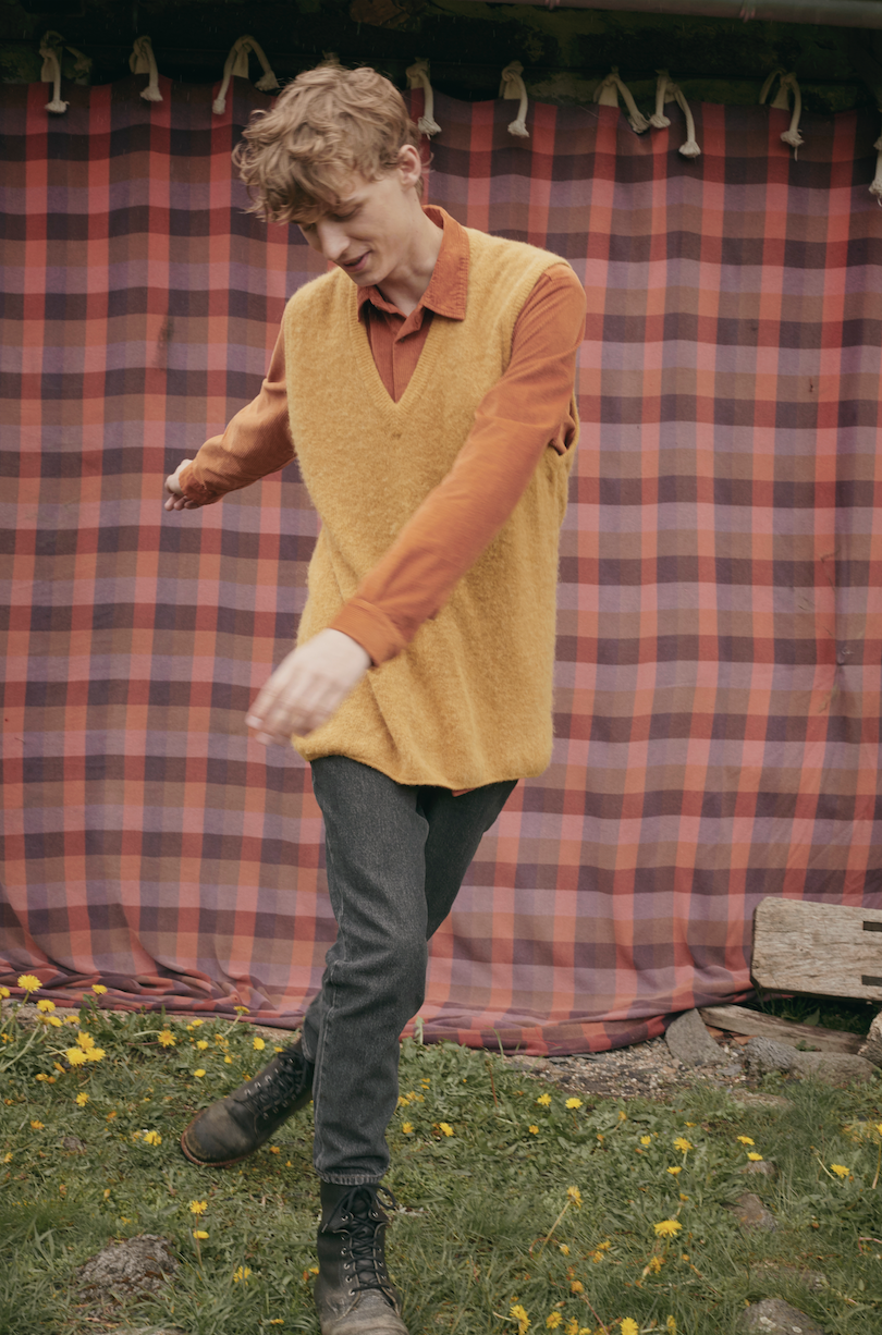 Man in American Vintage campaign dances in field.