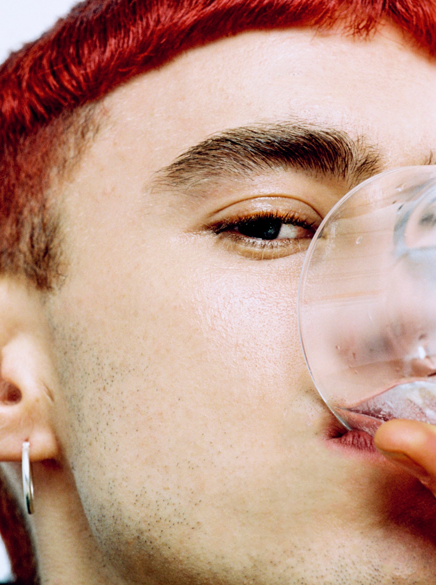 olly alexander drinking a glass of water