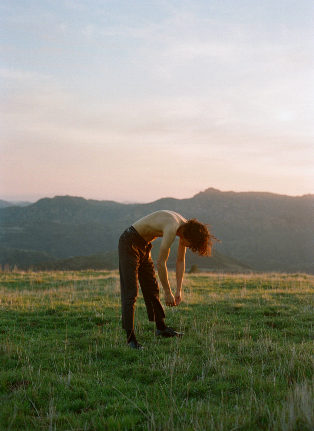 a man topless in a field