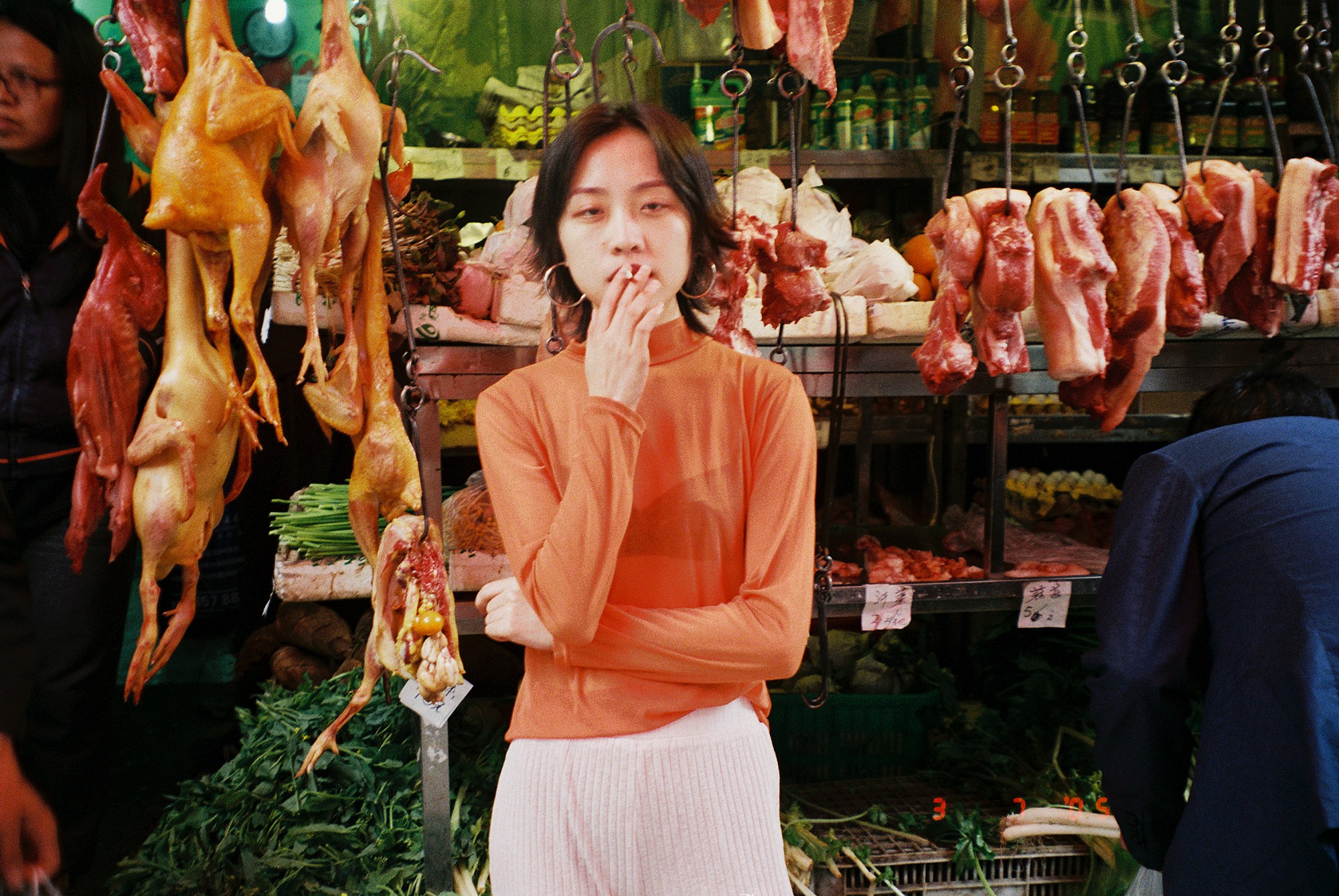 luo yang photographs a woman smoking in a market