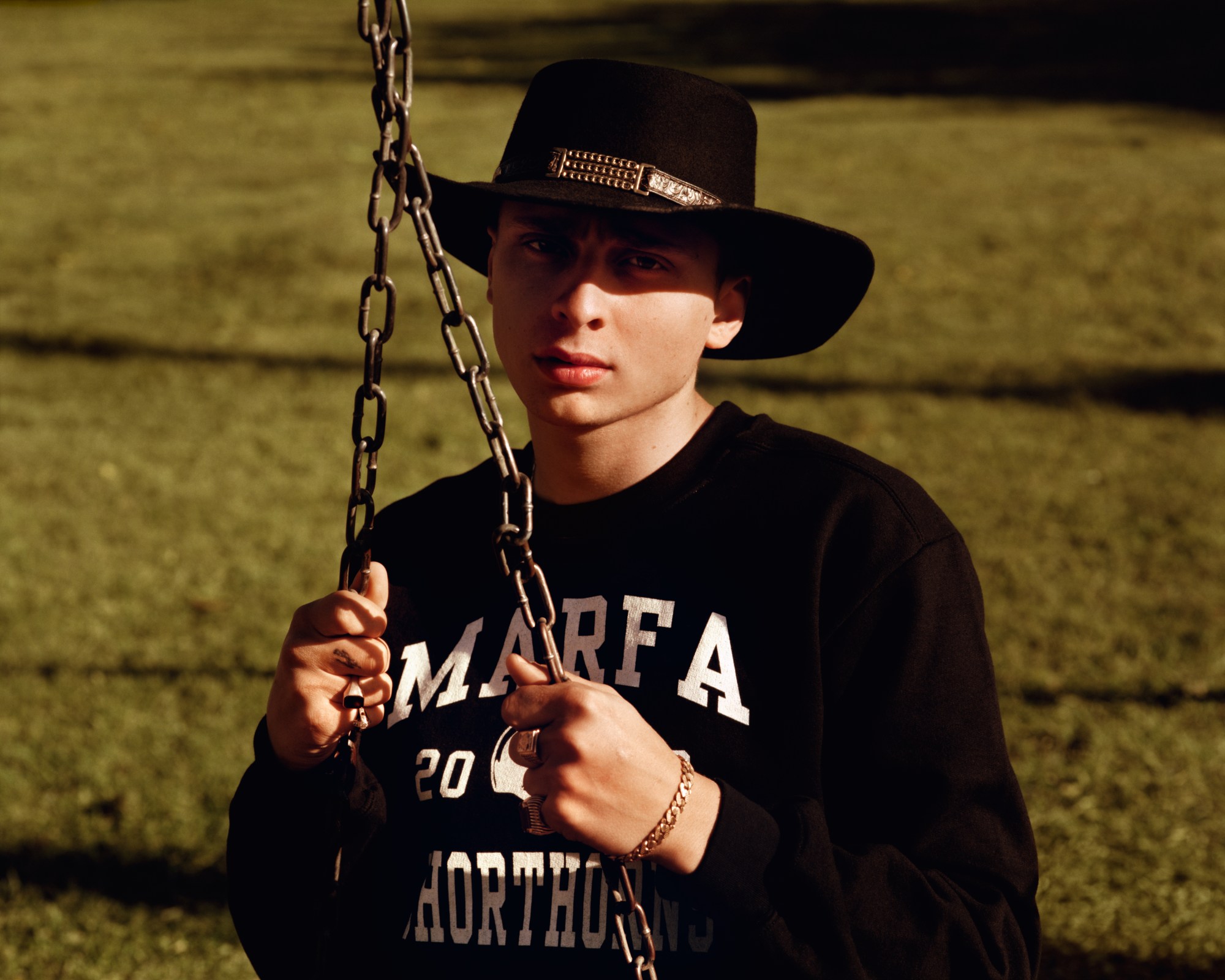 Blondey in a cowboy hat and on the playground swings