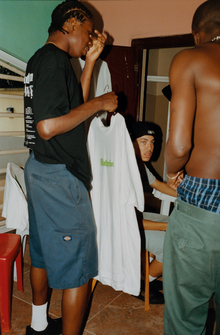 Three men talk in a kitchen