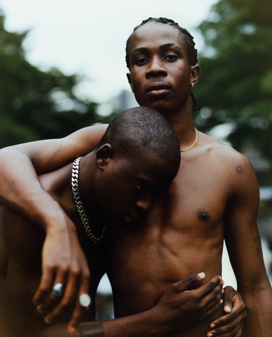 Two shirtless men embrace