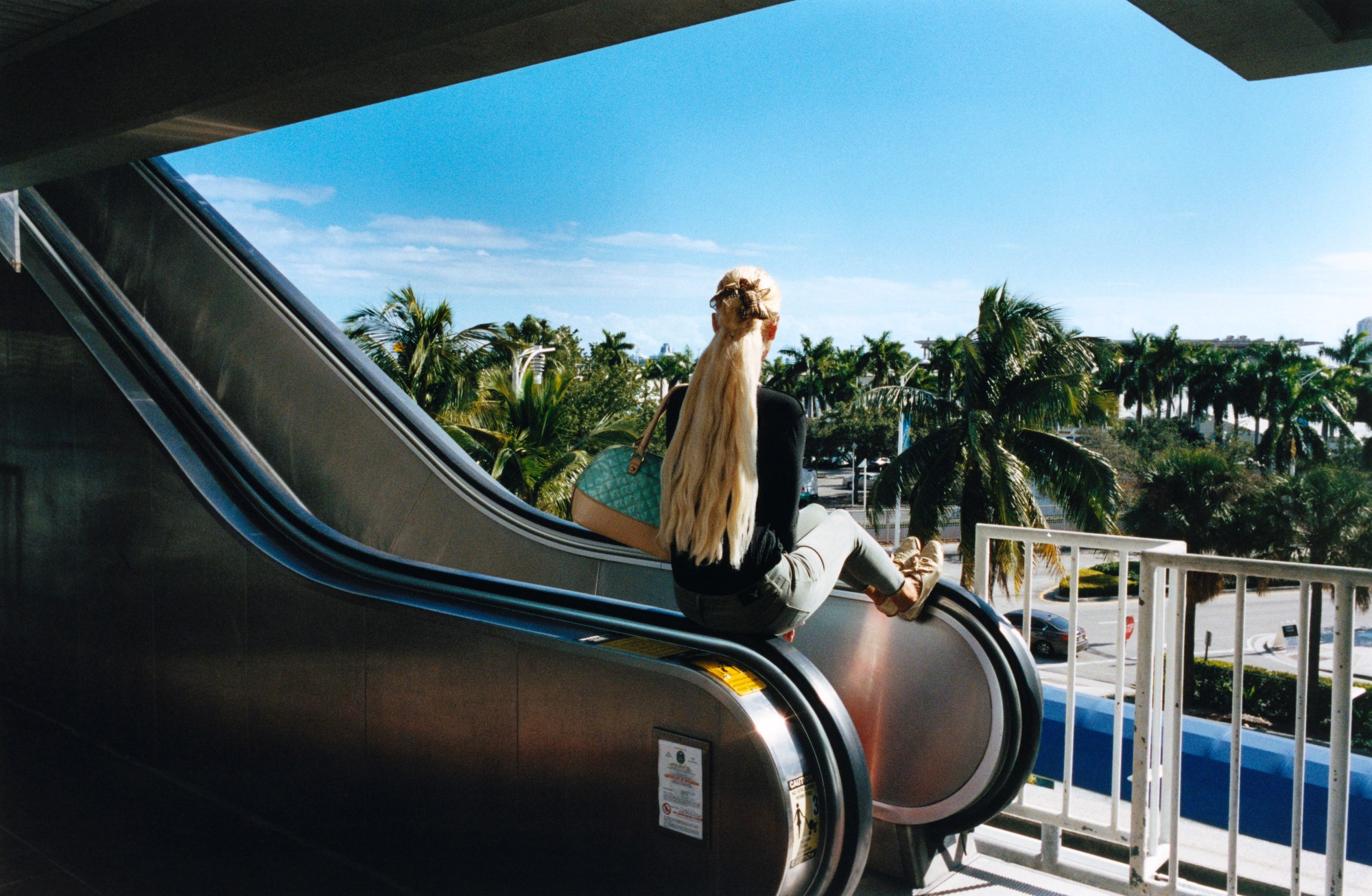 a woman sat on an escalator in miami