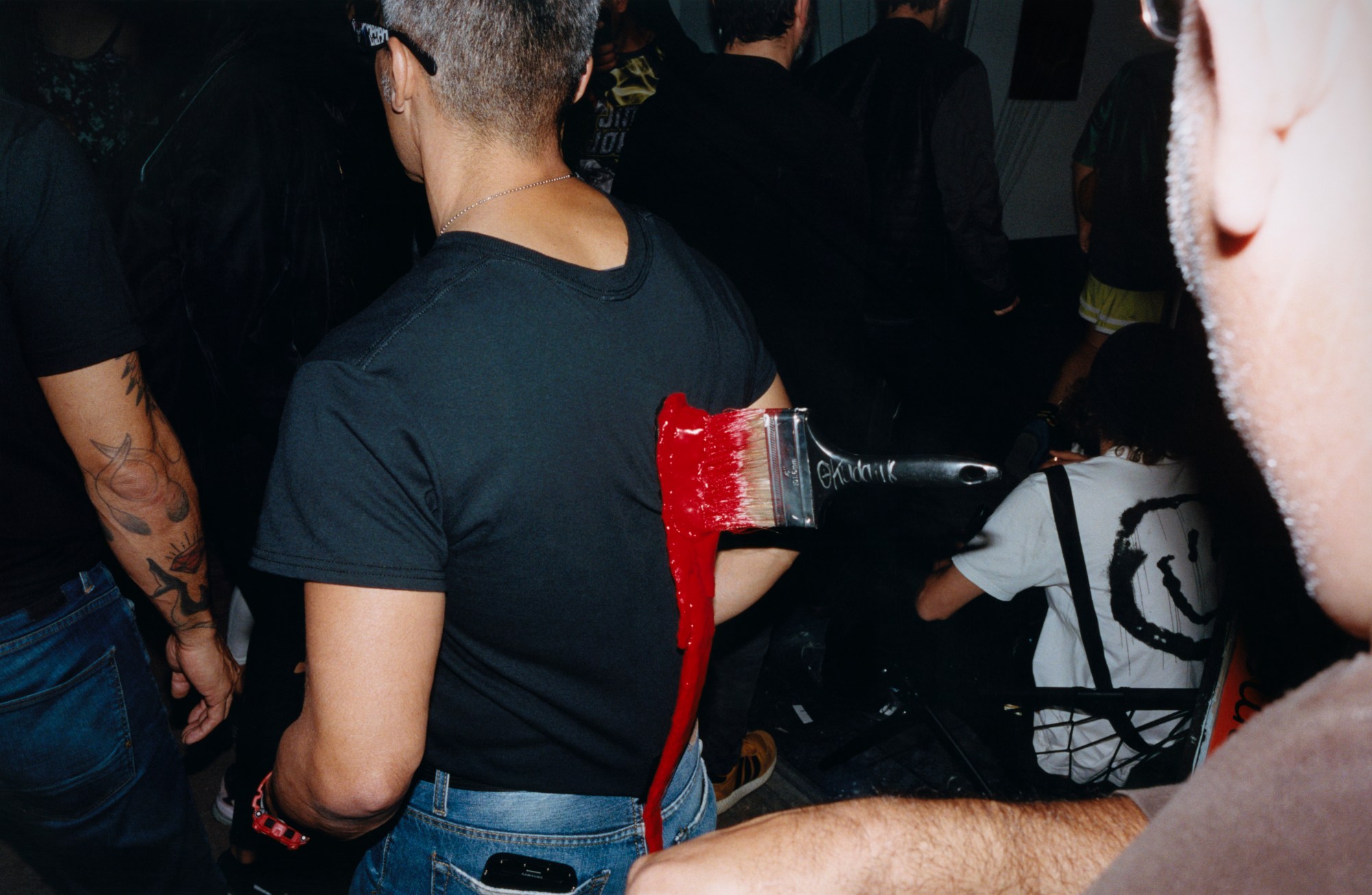 a man wearing a t-shirt with a paintbrush stuck to it