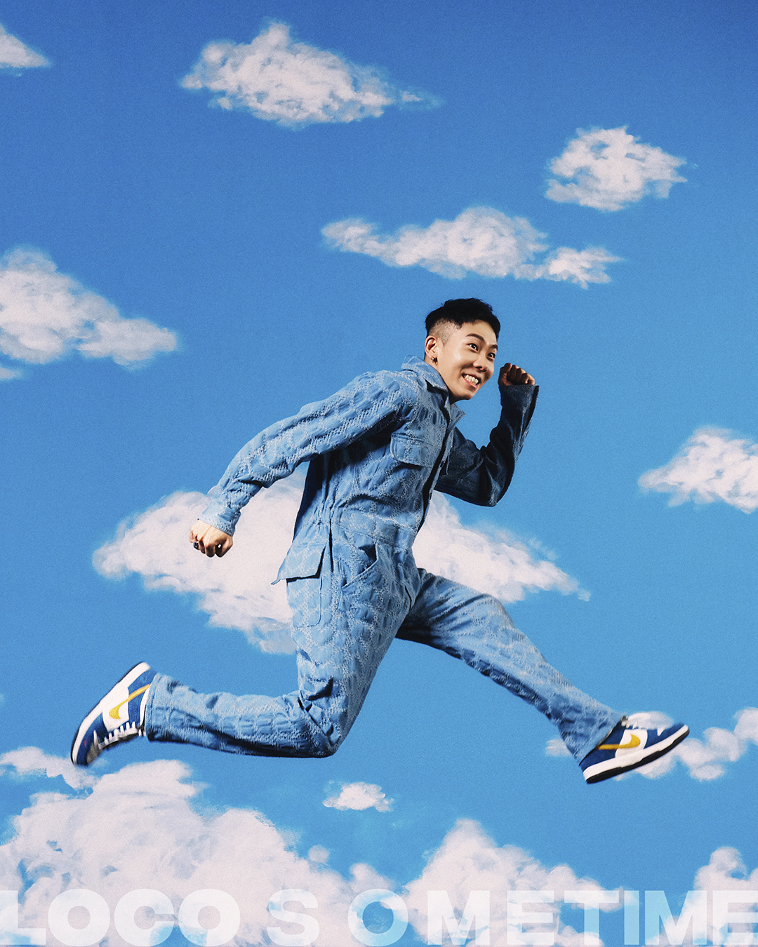 photograph of korean musician loco jumping in front of a sky backdrop