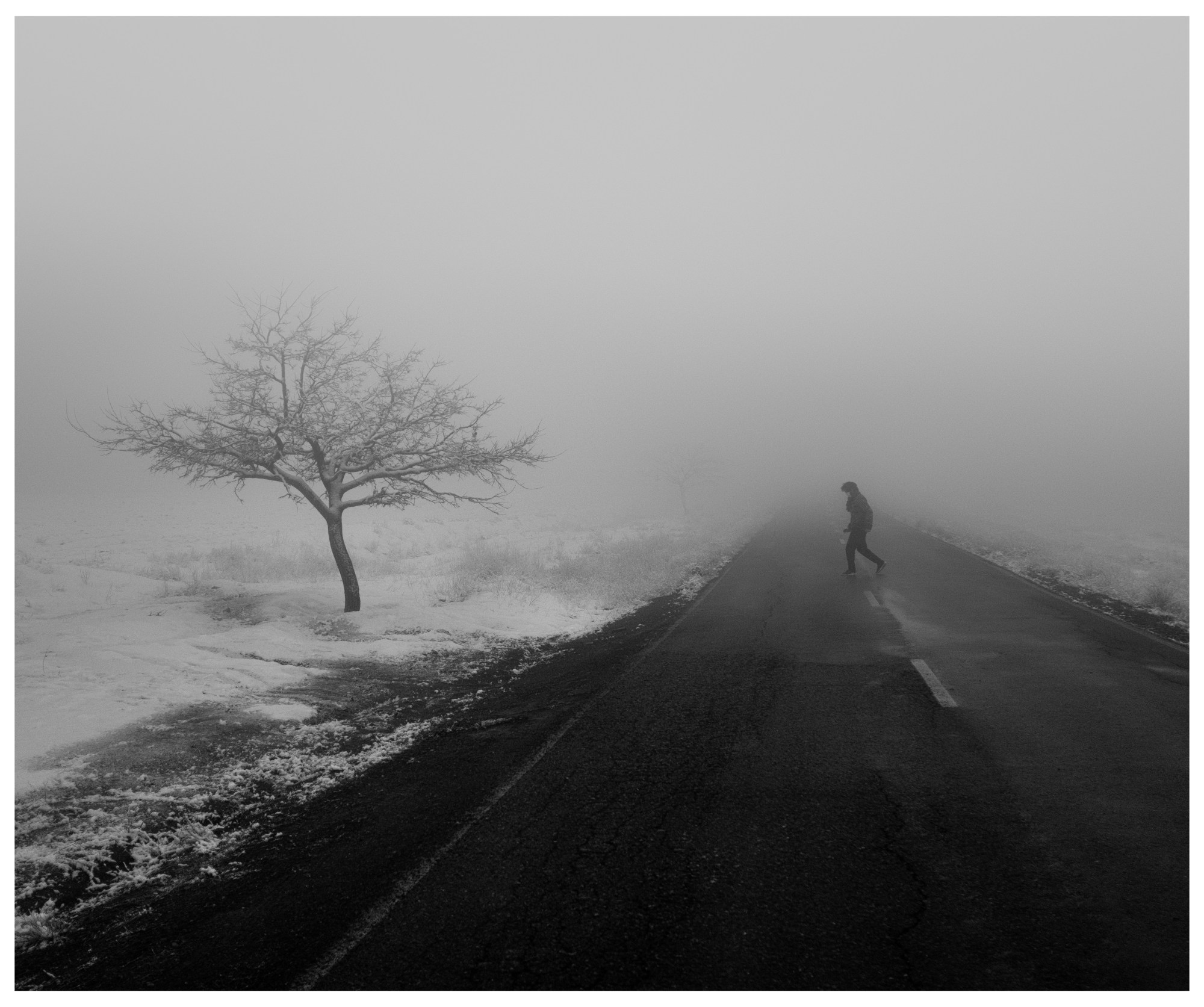 person walking across a frosty road