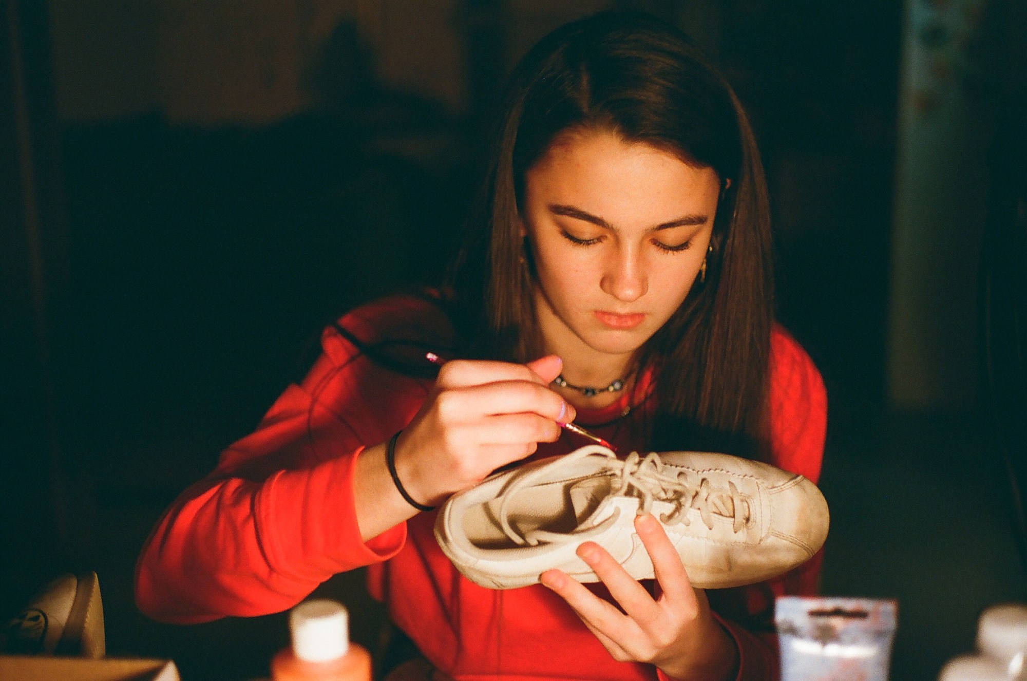 a girl painting a shoe