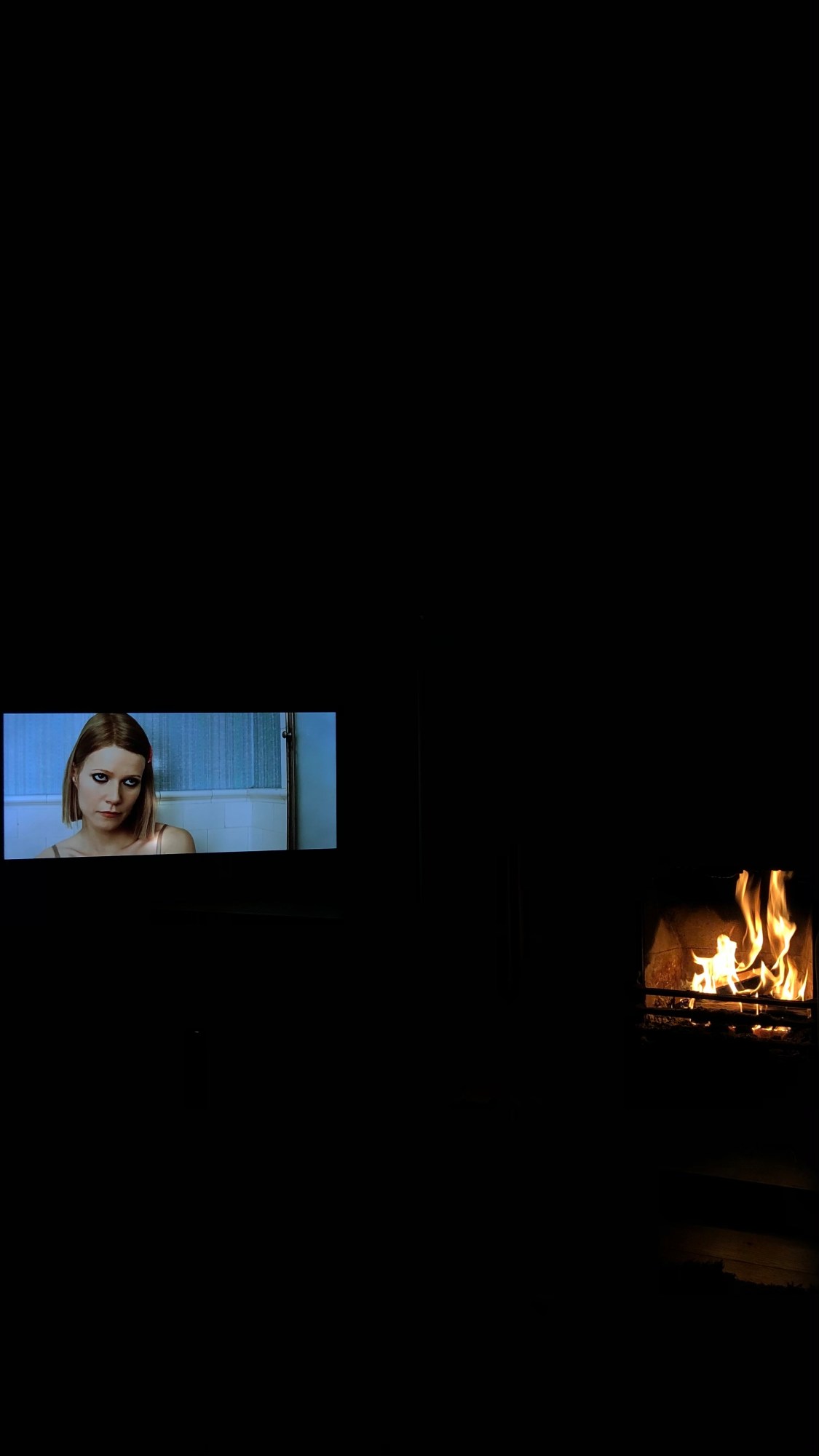 A tv screen and a fireplace at night