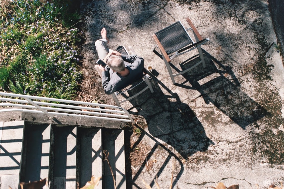 a man sat on his phone in the sun