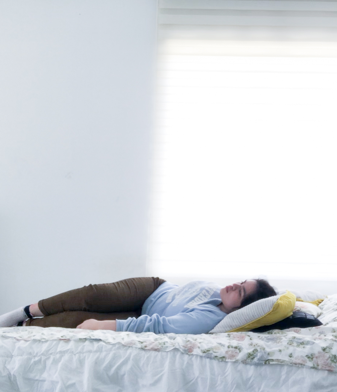 a woman lying on her bed staring into space