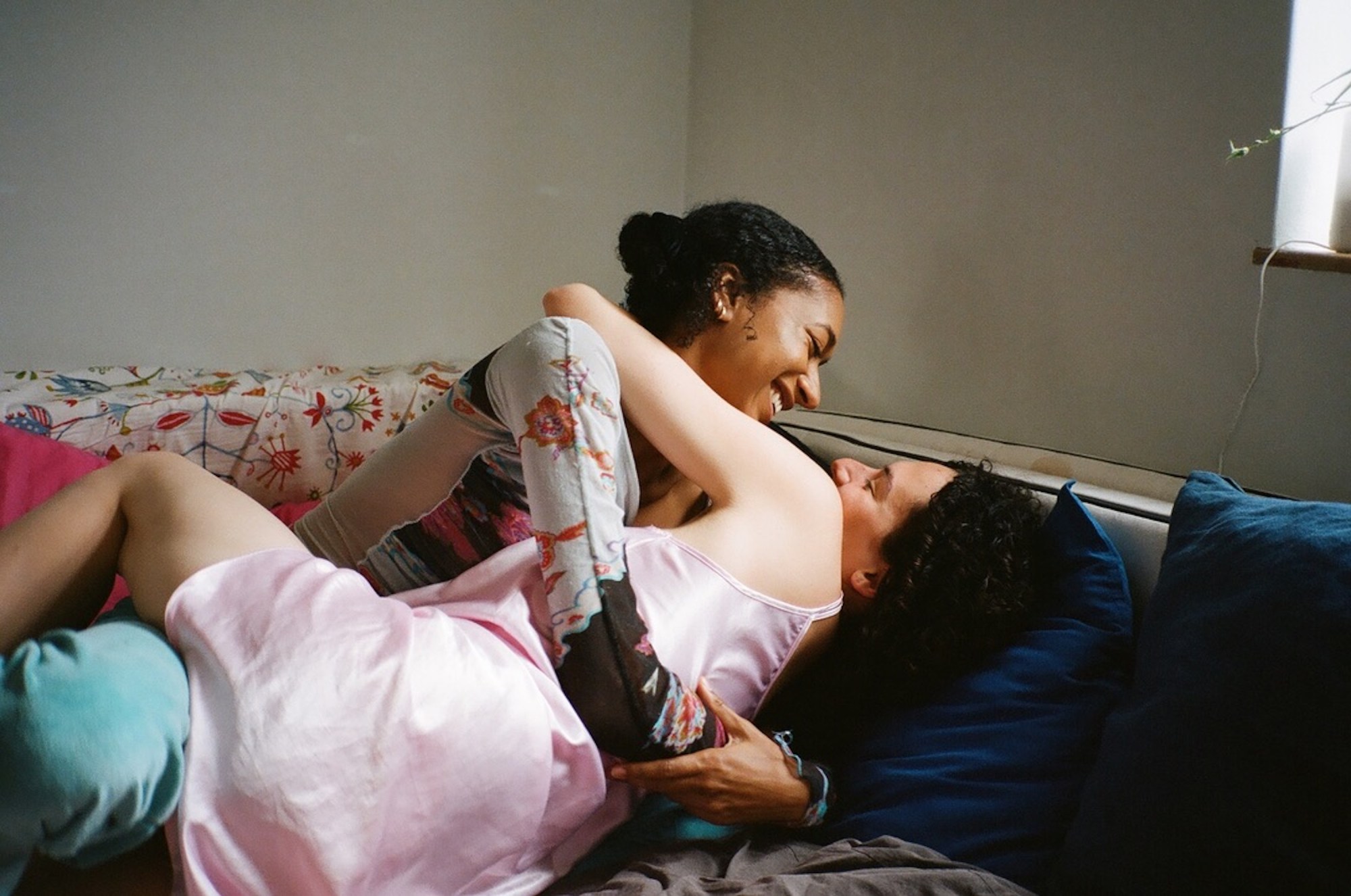 two girls embracing in bed