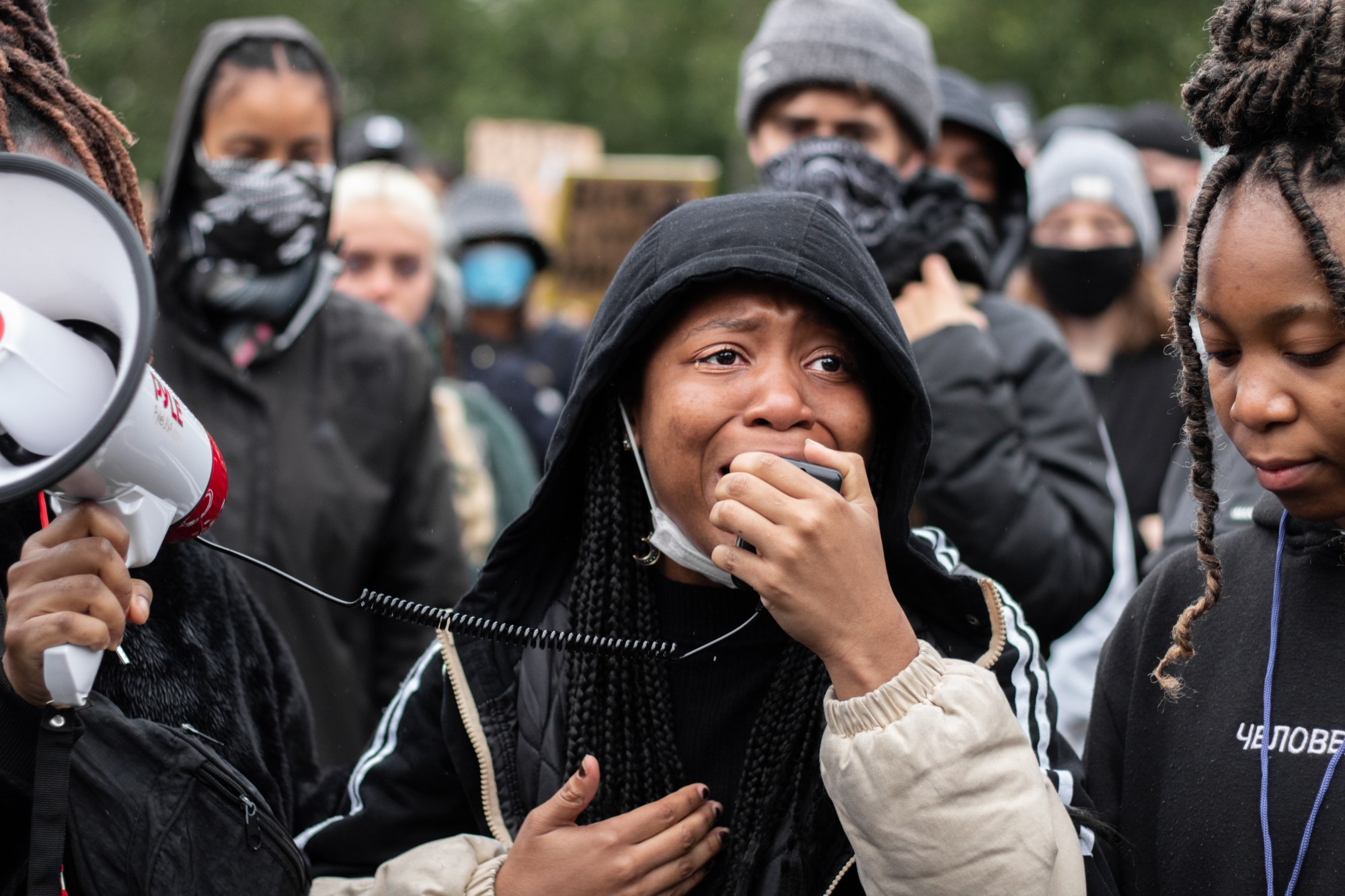 a woman at a protest speaking on a speakphone