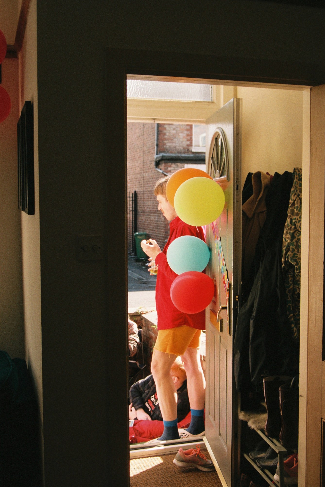 friends chatting on a doorstep with balloons on the door