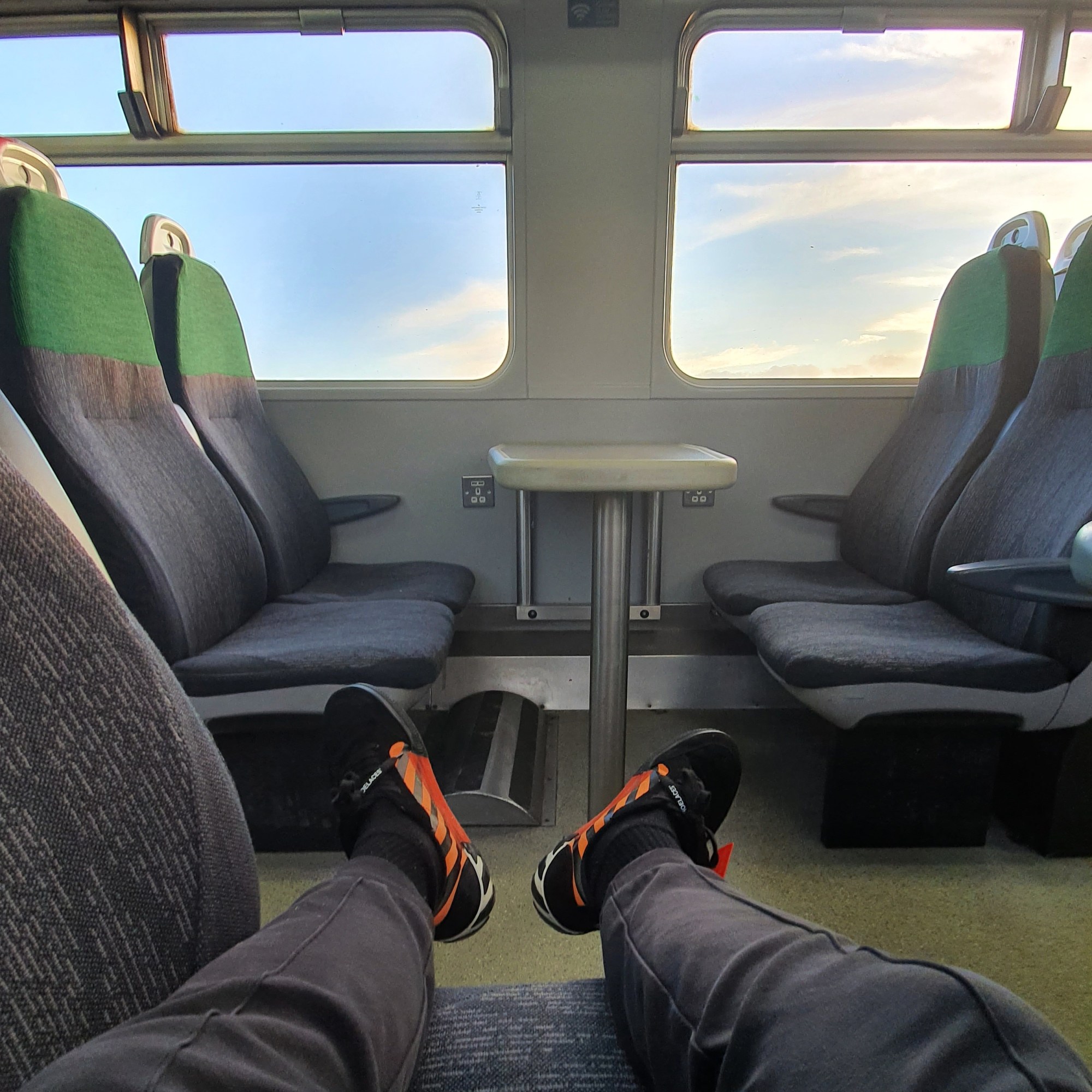 a man's legs and feet sticking out on a train