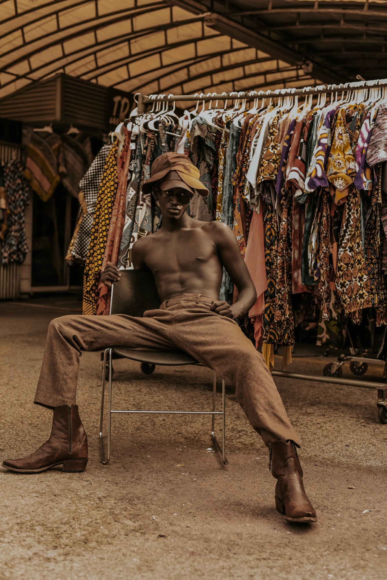 a man sat next to a rail of clothing