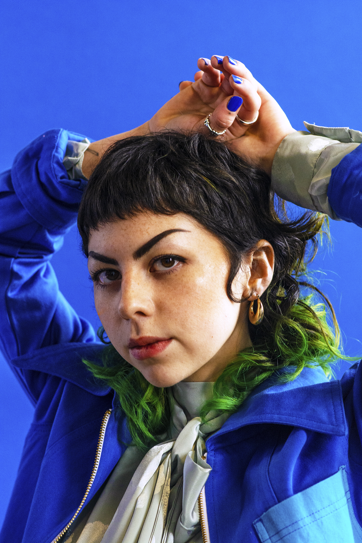 Woman in blue jacket and tie knot blouse. Photographed by Marcus Branch.