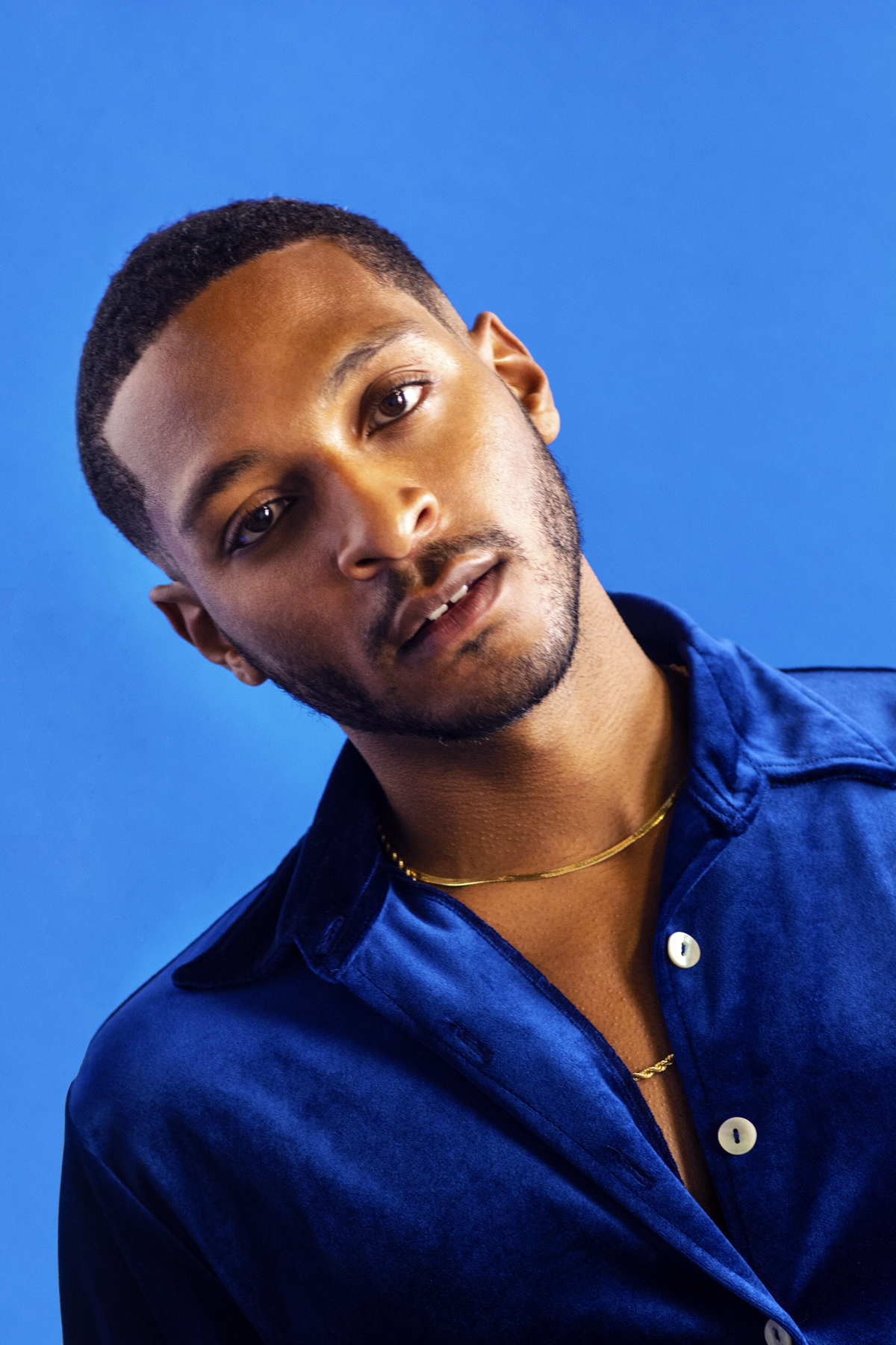 Man with blue velvet shirt and gold chain. Photographed by Marcus Branch.