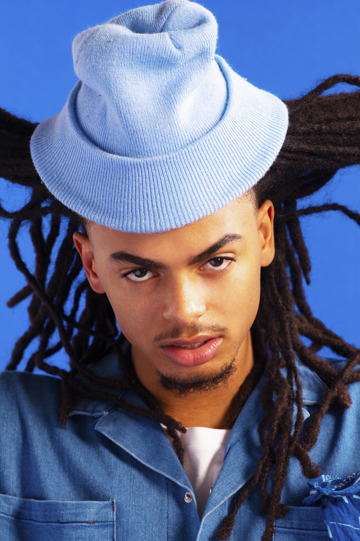 Man with a blue denim shirt, white t-shirt and blue beanie. Photographed by Marcus Branch.