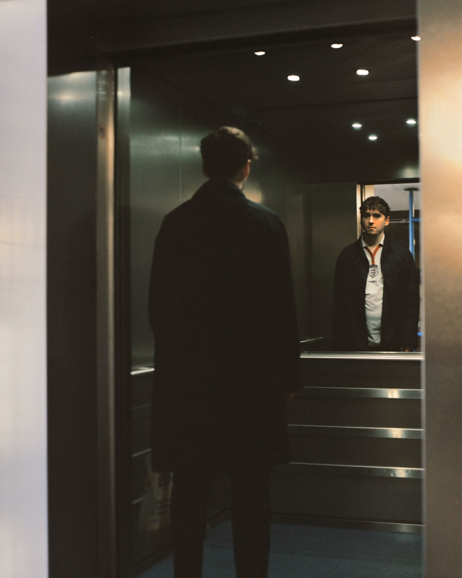 a man staring at a lift mirror