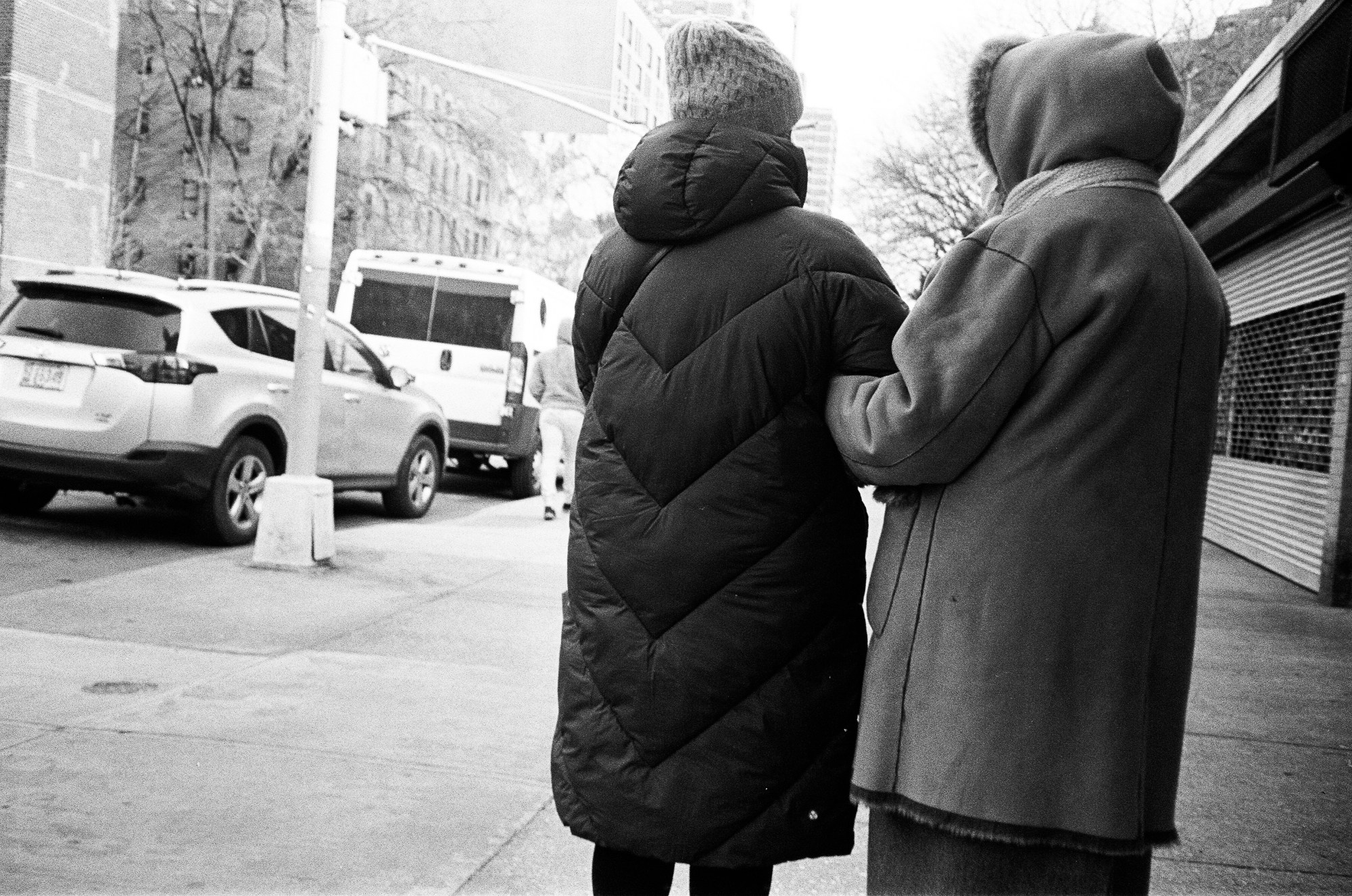 two women linking arms on the street