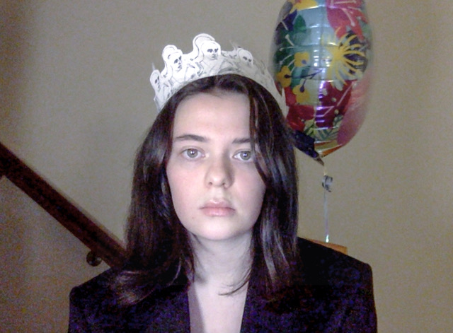 a webcam picture of a girl and a birthday balloon