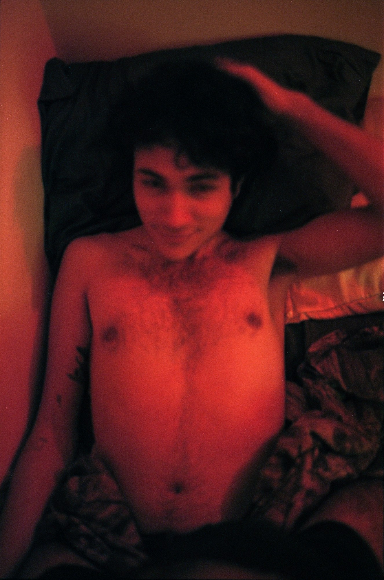 a topless man lying in bed