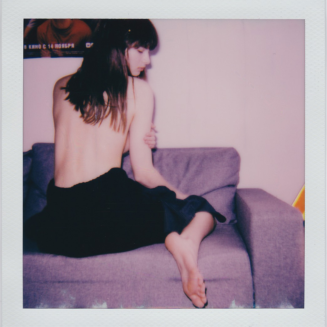 a topless woman sat on a sofa