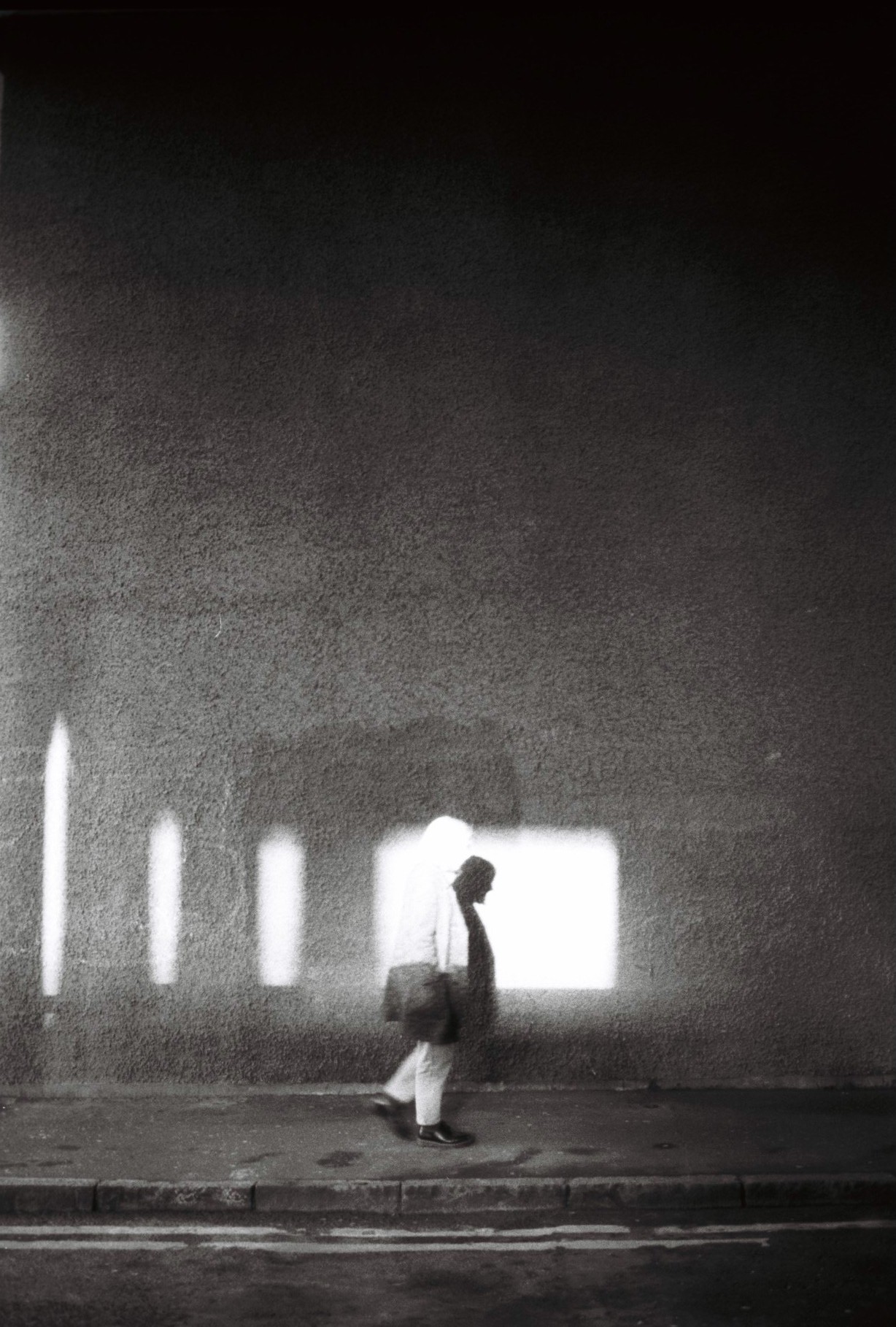 a man walking down a street with light reflected across him