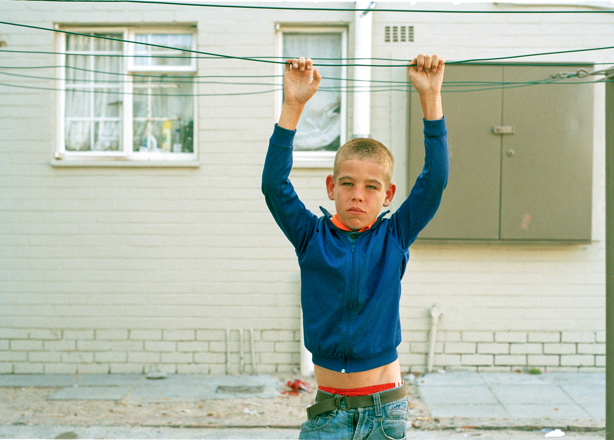 a young boy holding onto a washing line