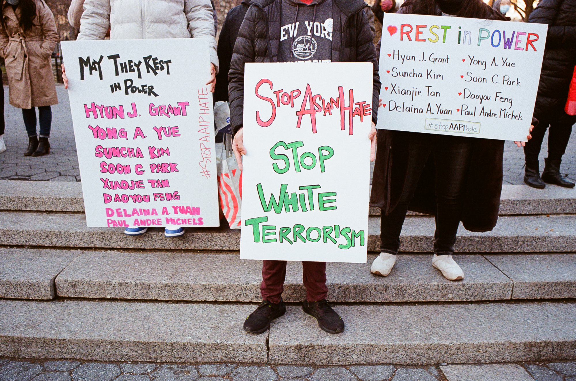 three placards that honour the victims of the atlanta terrorist attack and call for an end of asian hate and white terrorism