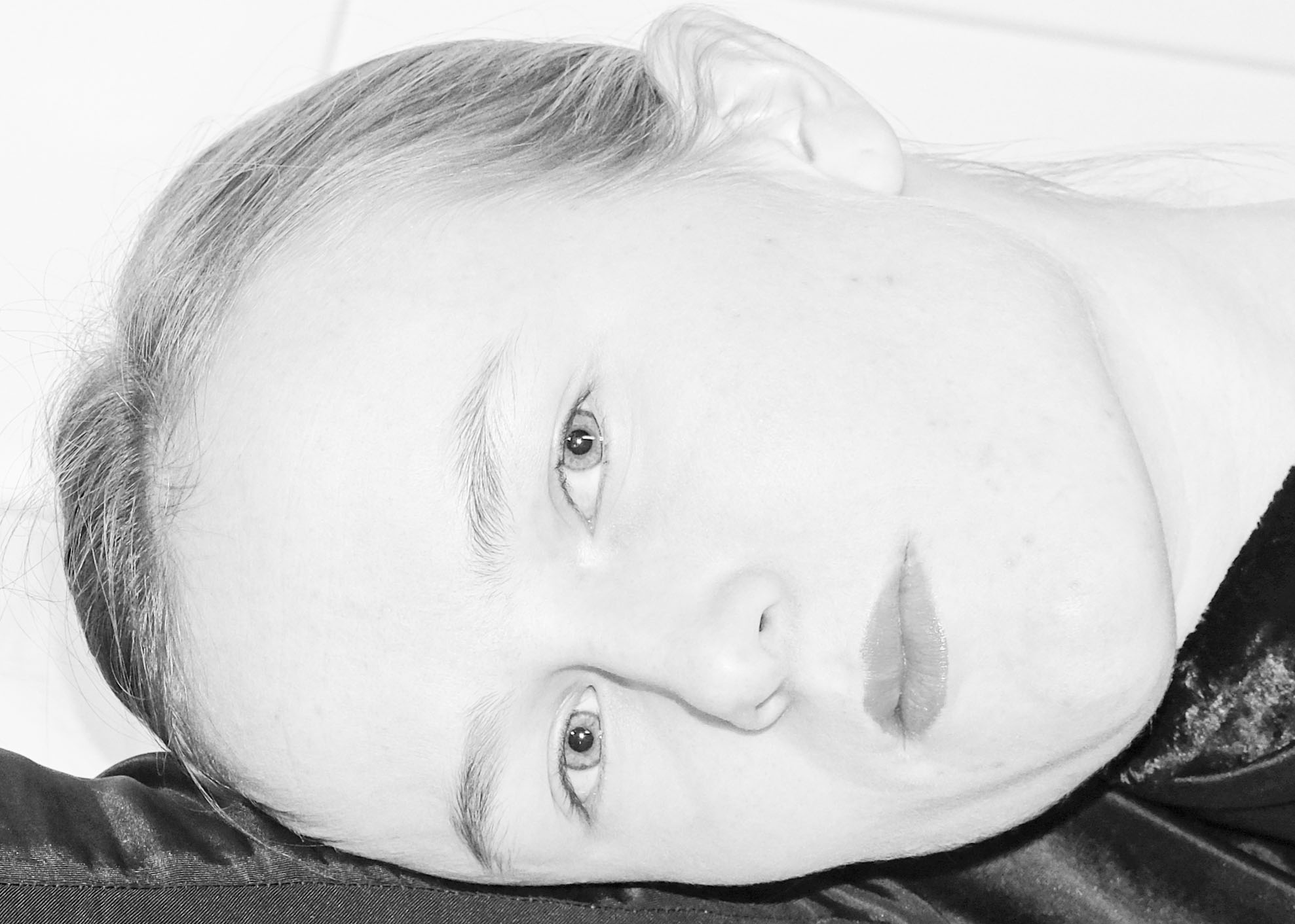 a girl's face in black-and-white lying on her arm