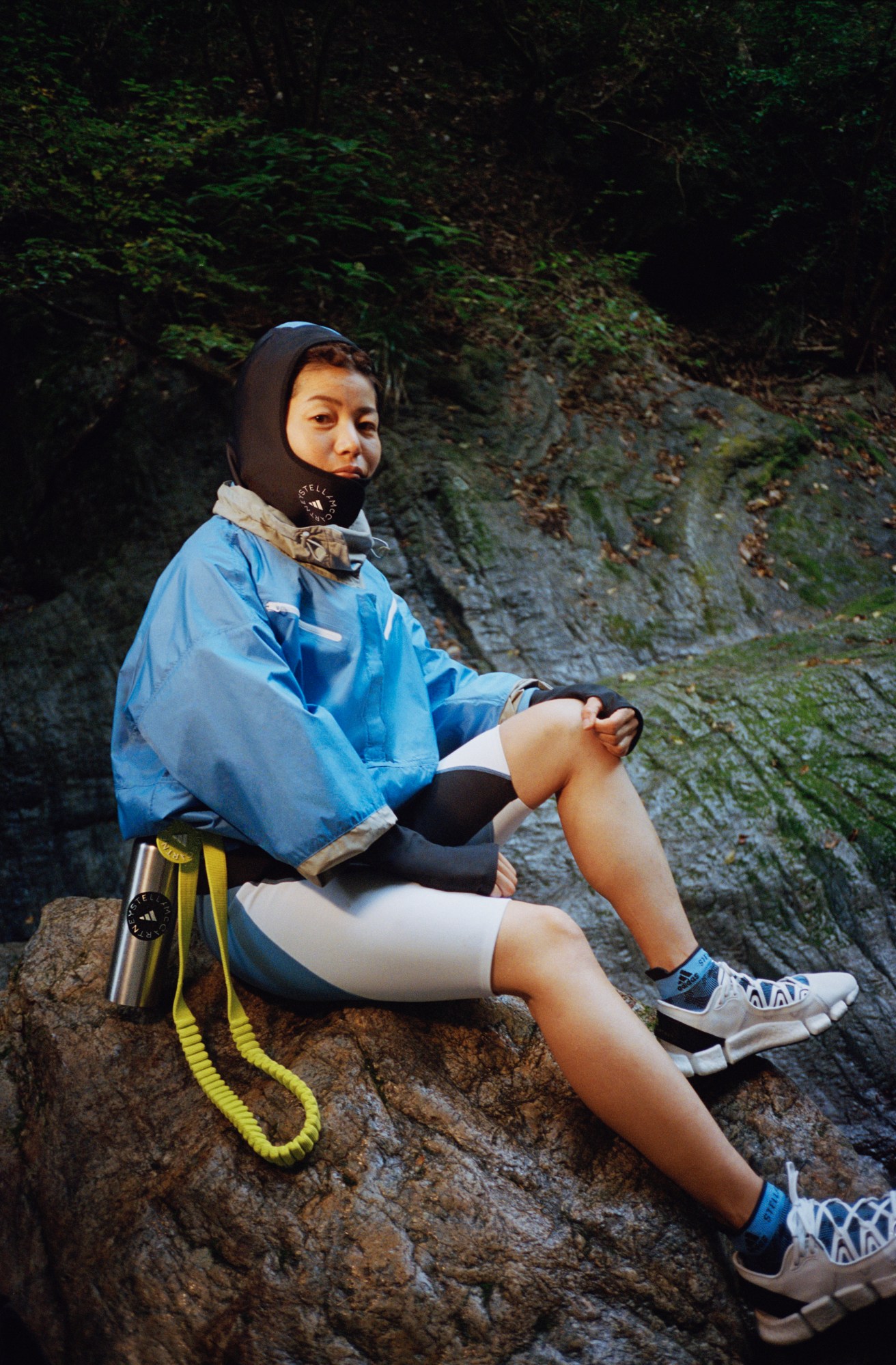 Girl on rocks wearing adidas by Stella McCartney SS21 shoes and jacket