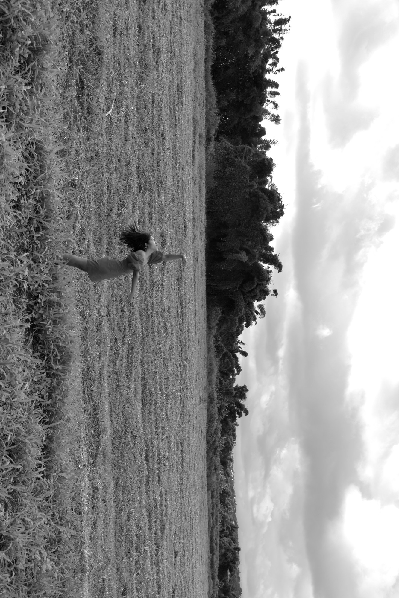 the image is rotated 90 degrees, a woman stands in a field on the island of la reunion