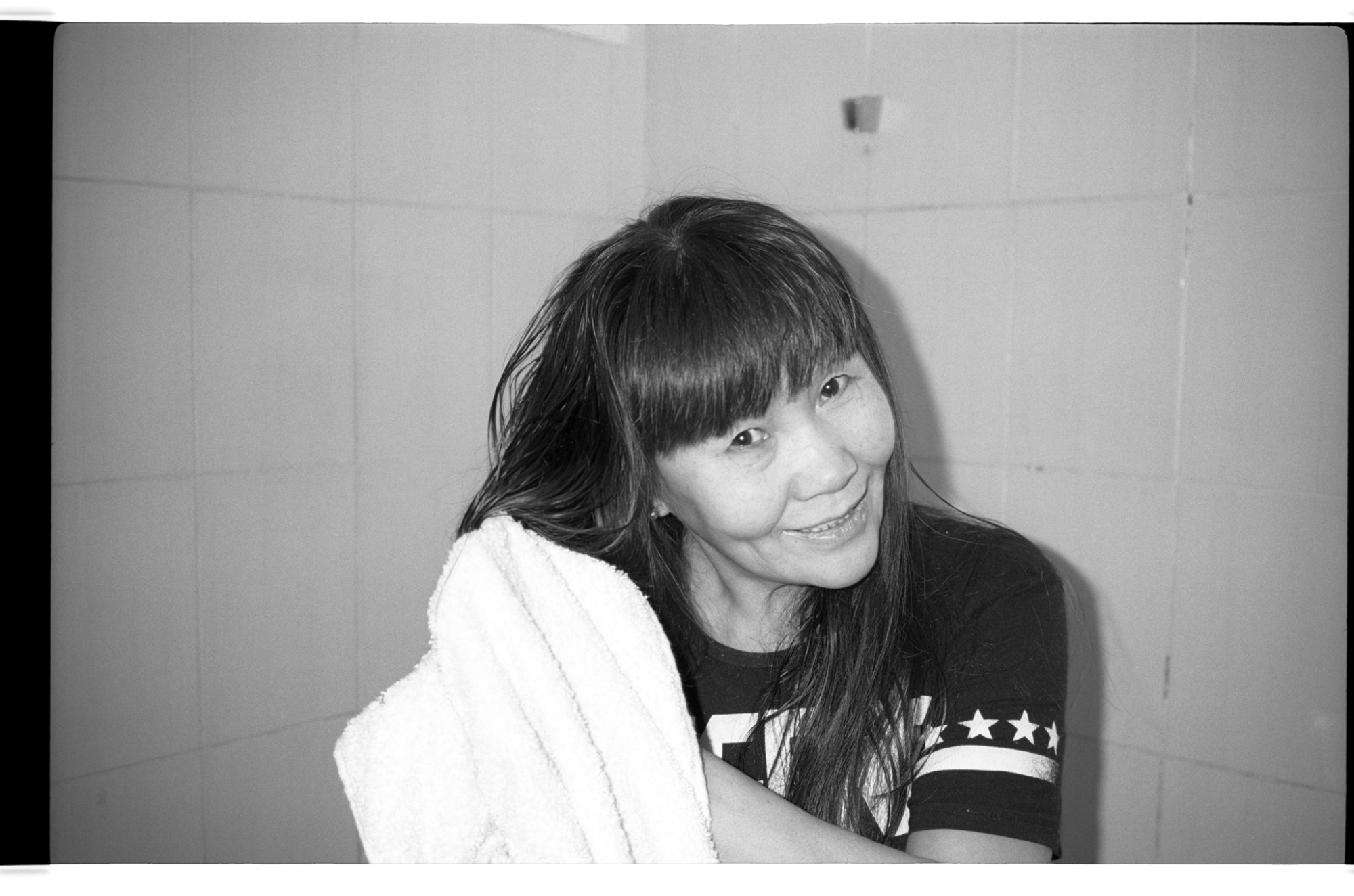 a woman dries her hair with a towel