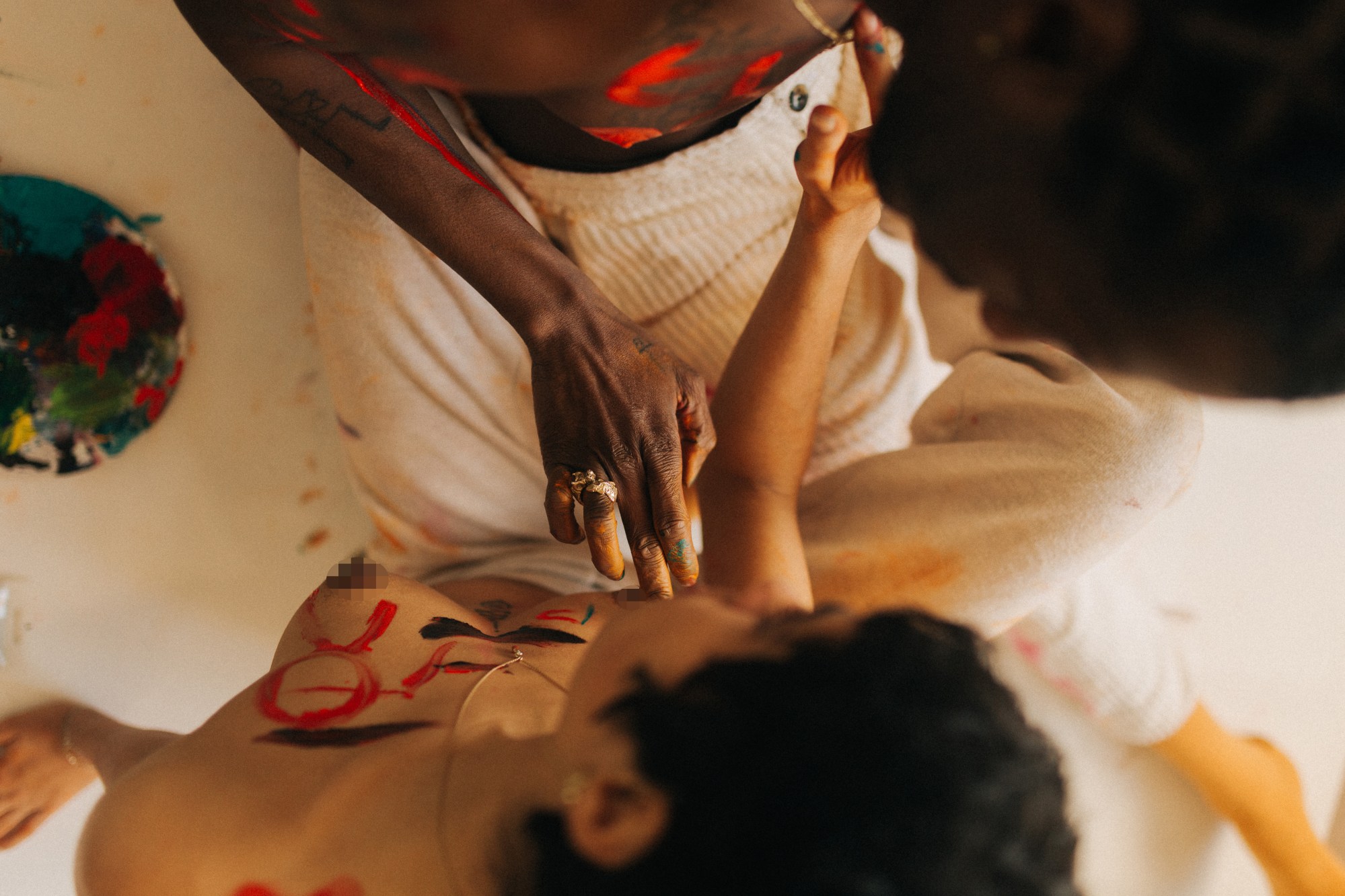 a man and a woman covered in paint touch each other