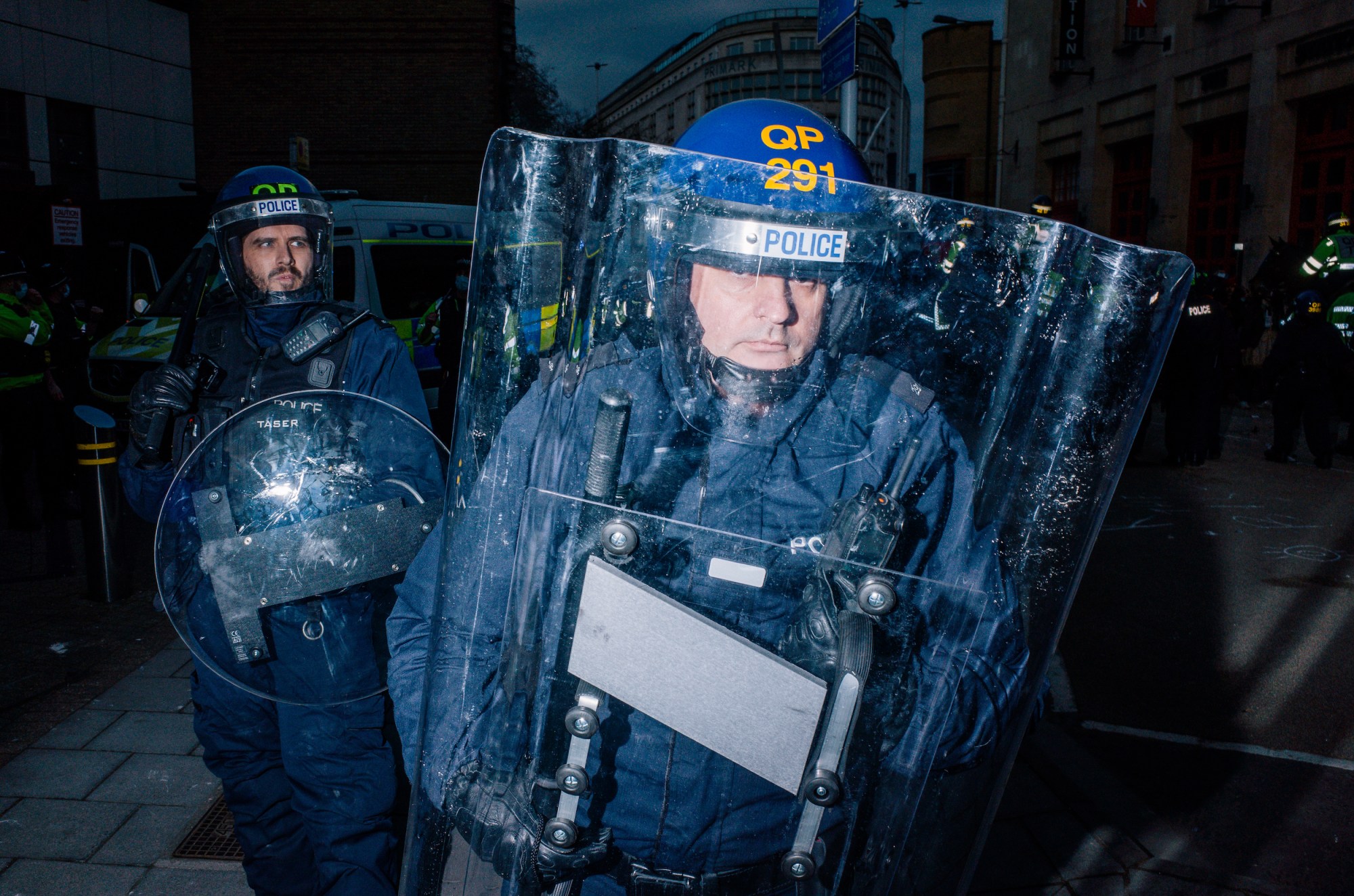 riot police holding up transparent shields