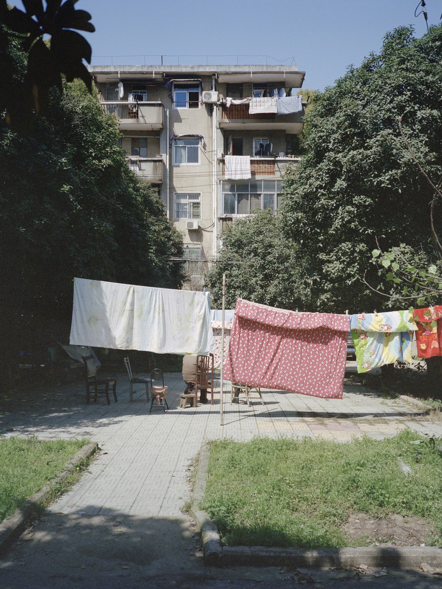 sheets hanging in the garden of an apartment block