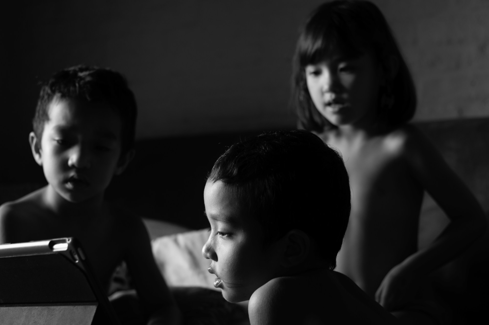 three children all look at something out of view of the camera