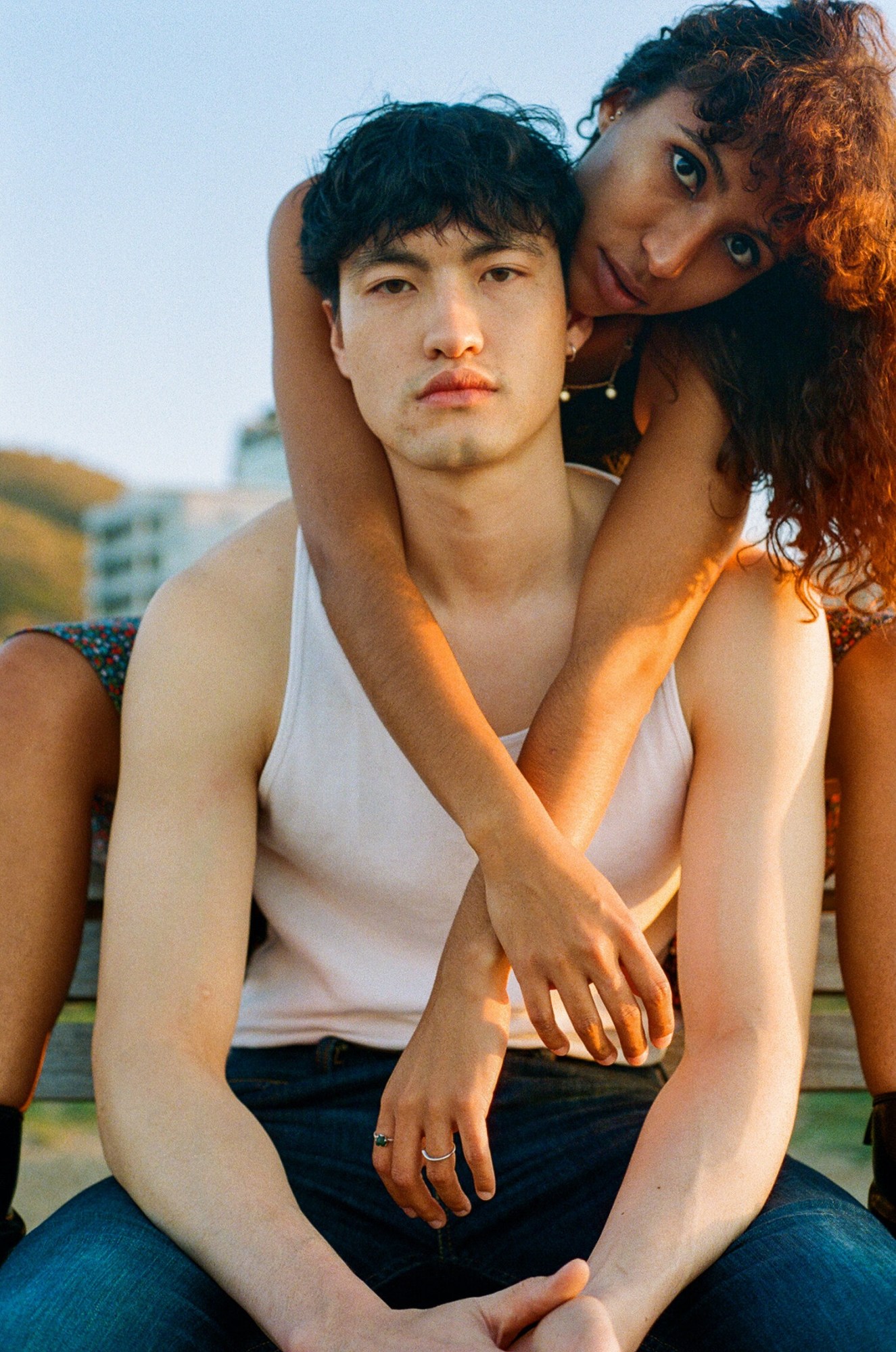 a woman hangs over a man's shoulders