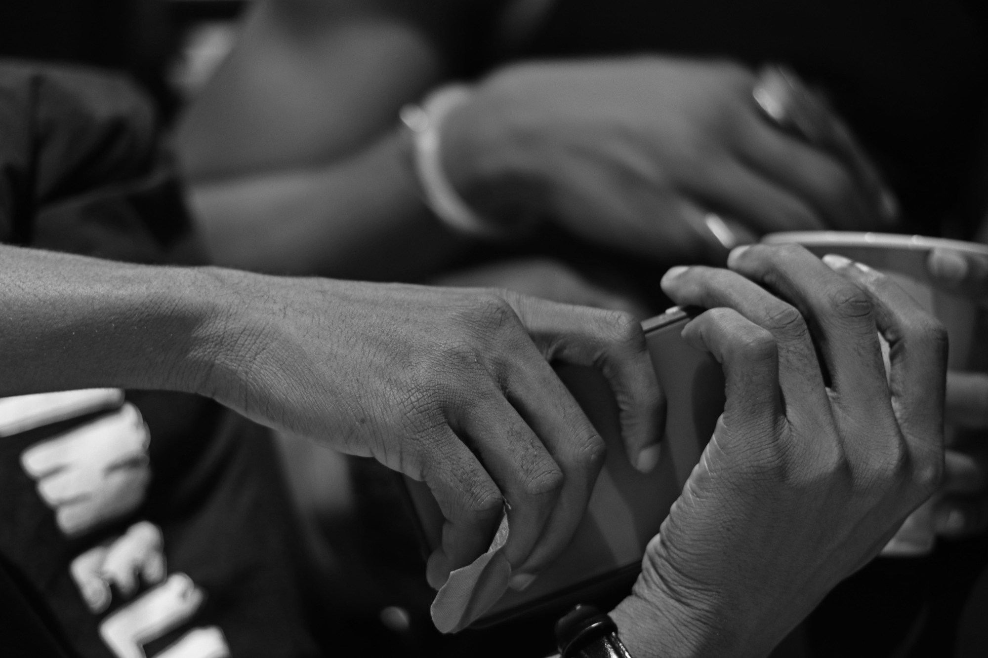 two pairs of hands holding phones