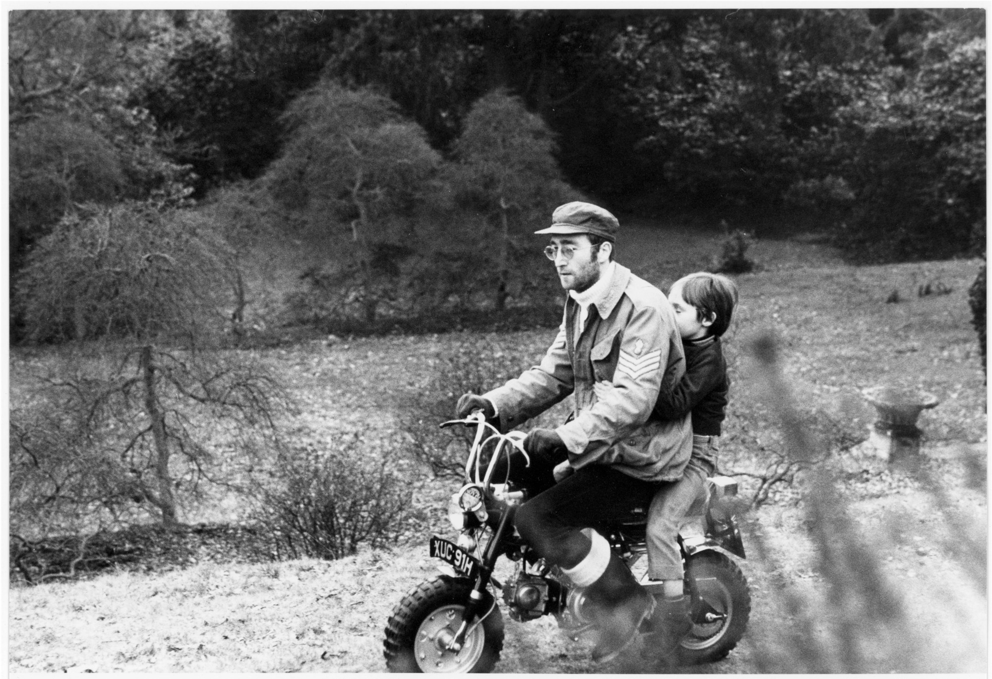 John Lennon giving son Julian Lennon a ride on the back of a mini motorbike