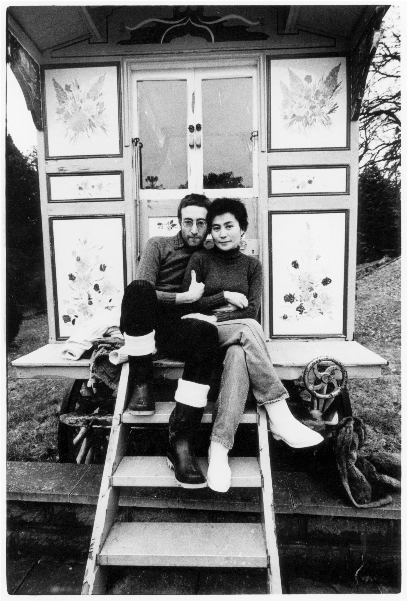 John and Yoko sitting on the steps of their Sgt. Pepper caravan