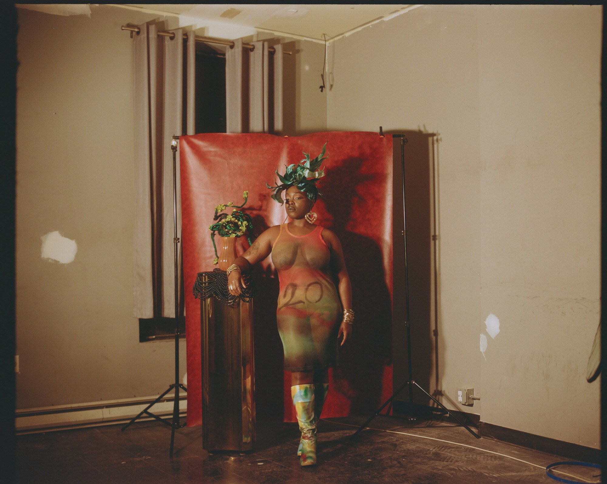 woman standing in front of a backdrop in a headress