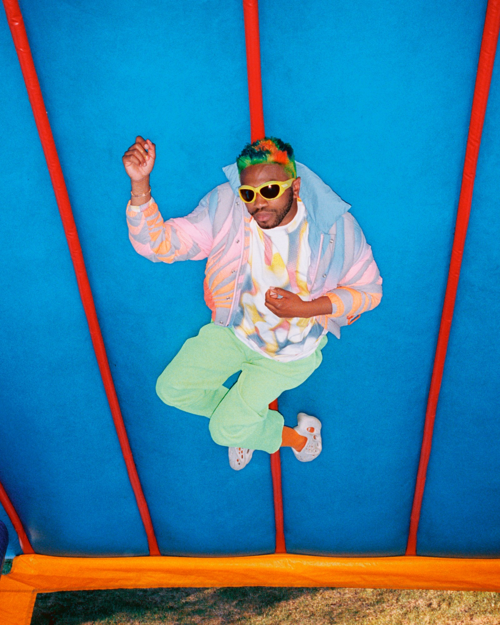 Kevin Abstract laying down on a blue bouncy castle