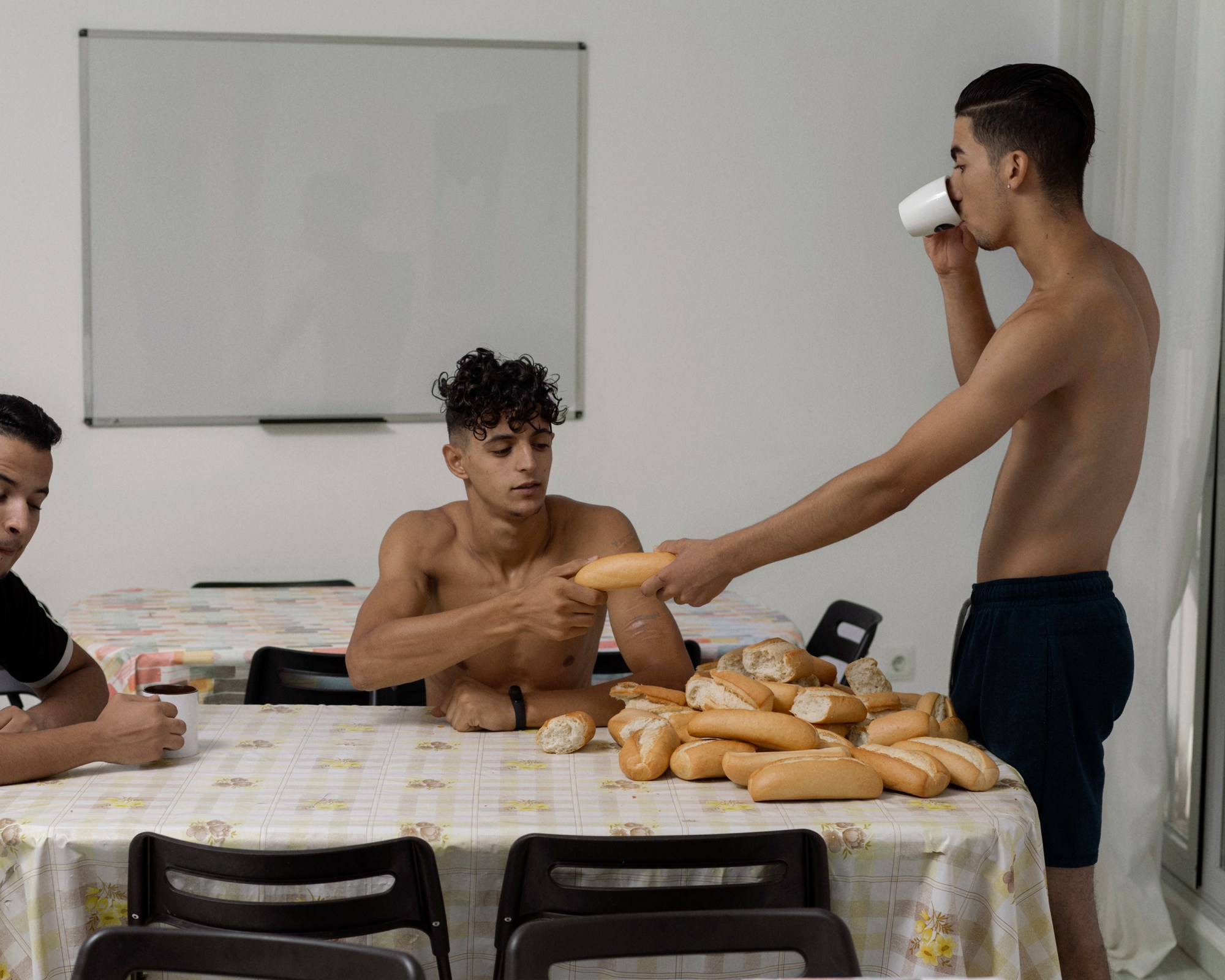 two moroccan boys sharing bread in a migrant centre in spain