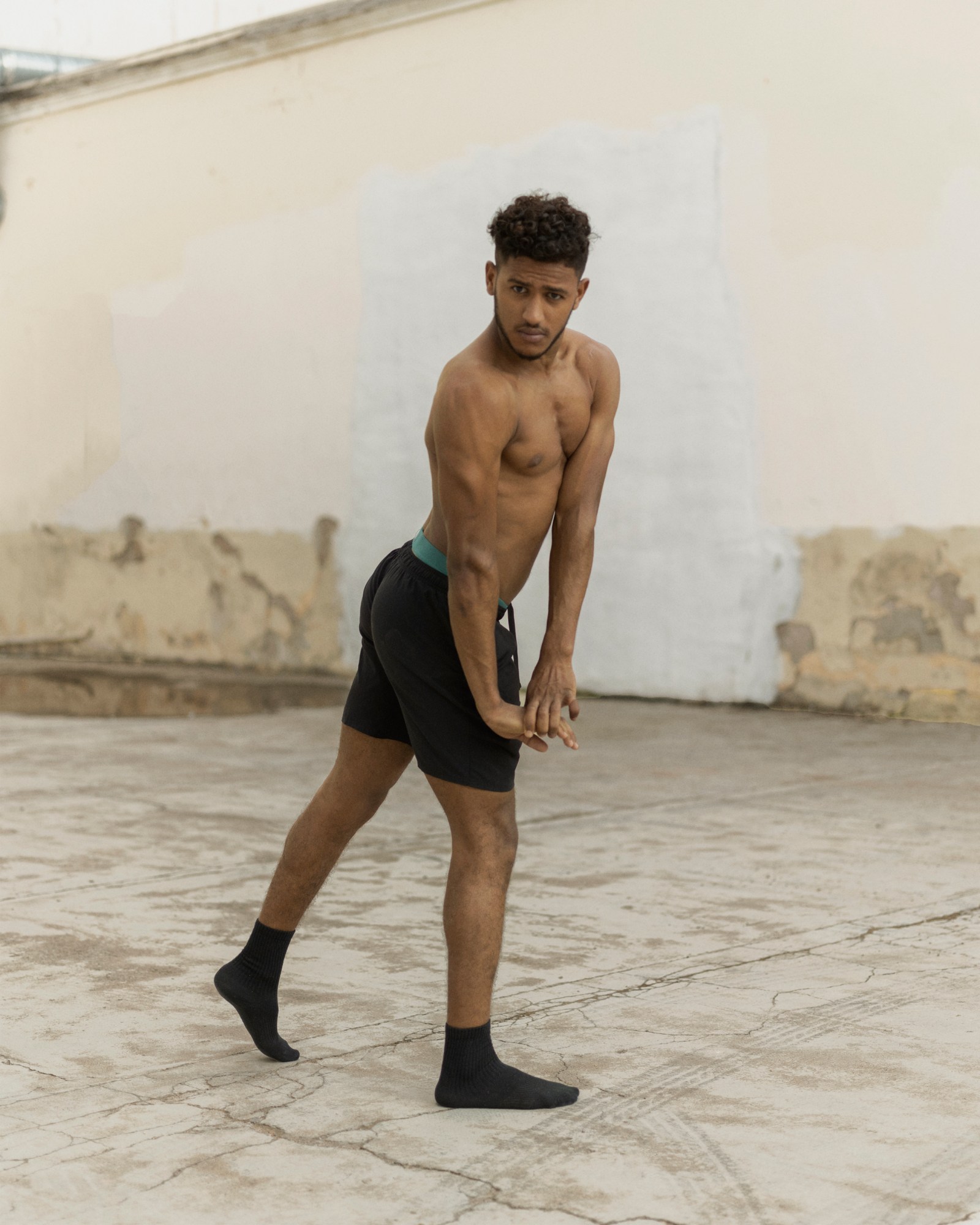 boy poses shirtless in a courtyard in a migrant centre in spain