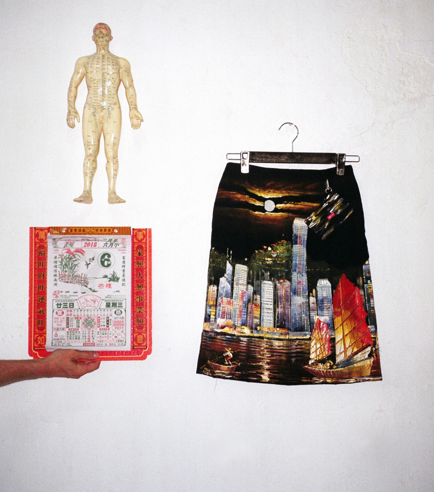 An anatomical medical model, a page from a calendar and a skirt by Hong Kong designer Yat Pit featuring the HK skyline