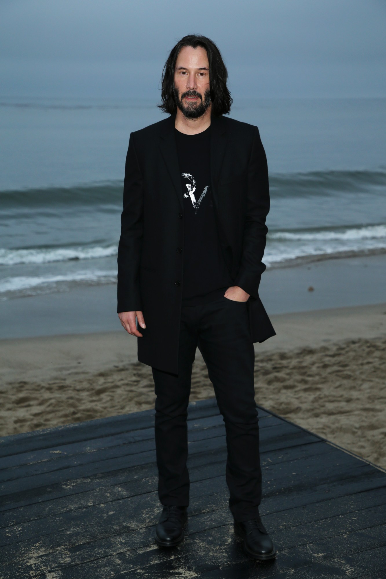 keanu reeves standing on the beach at the Saint Laurent SS20 menswear show