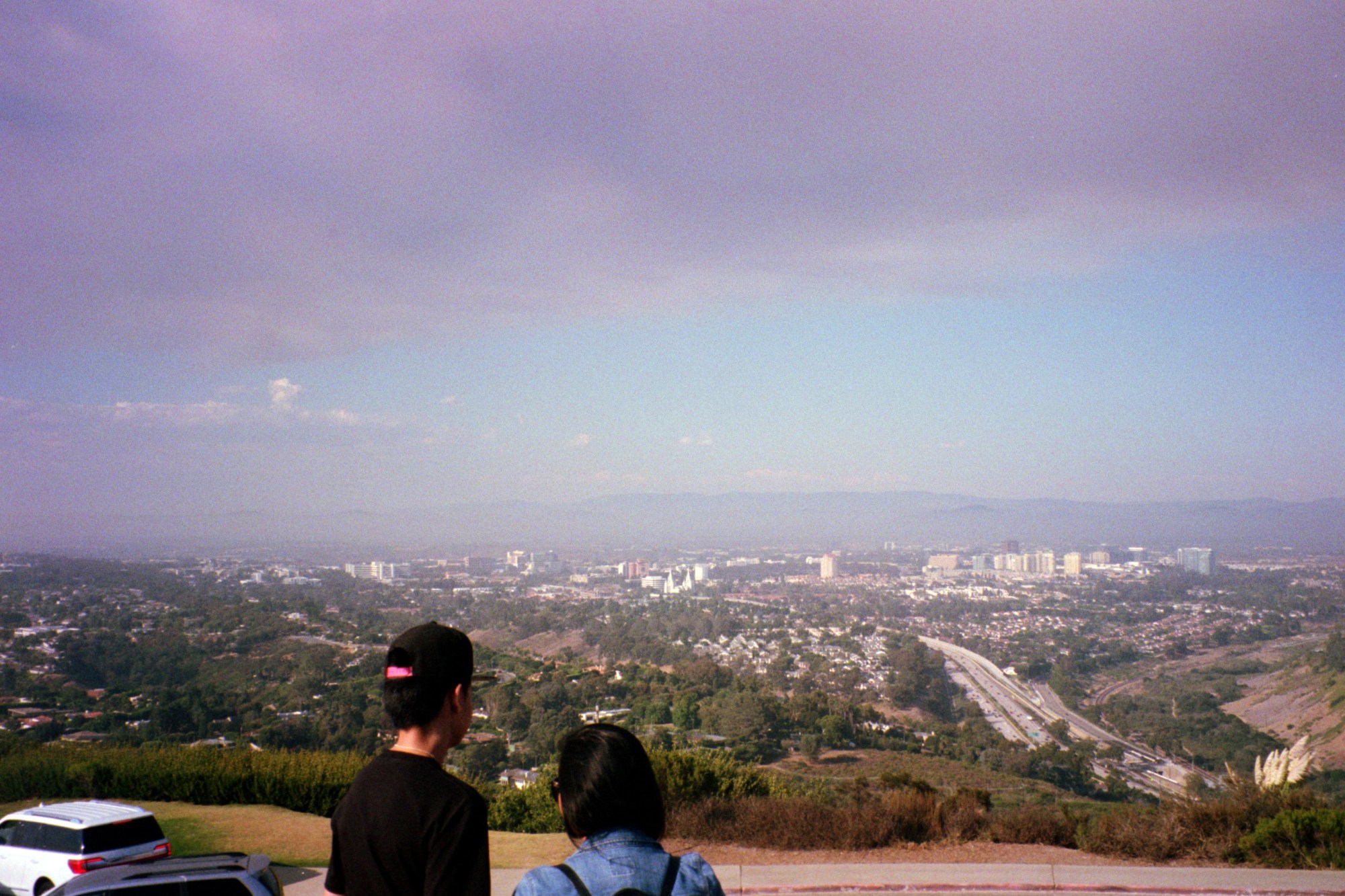 Two people looking over a smoggy vista.